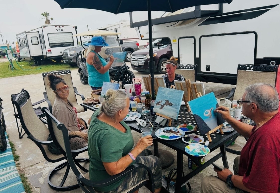 Guests enjoying an outdoor painting session right at their site — community and creativity at its best